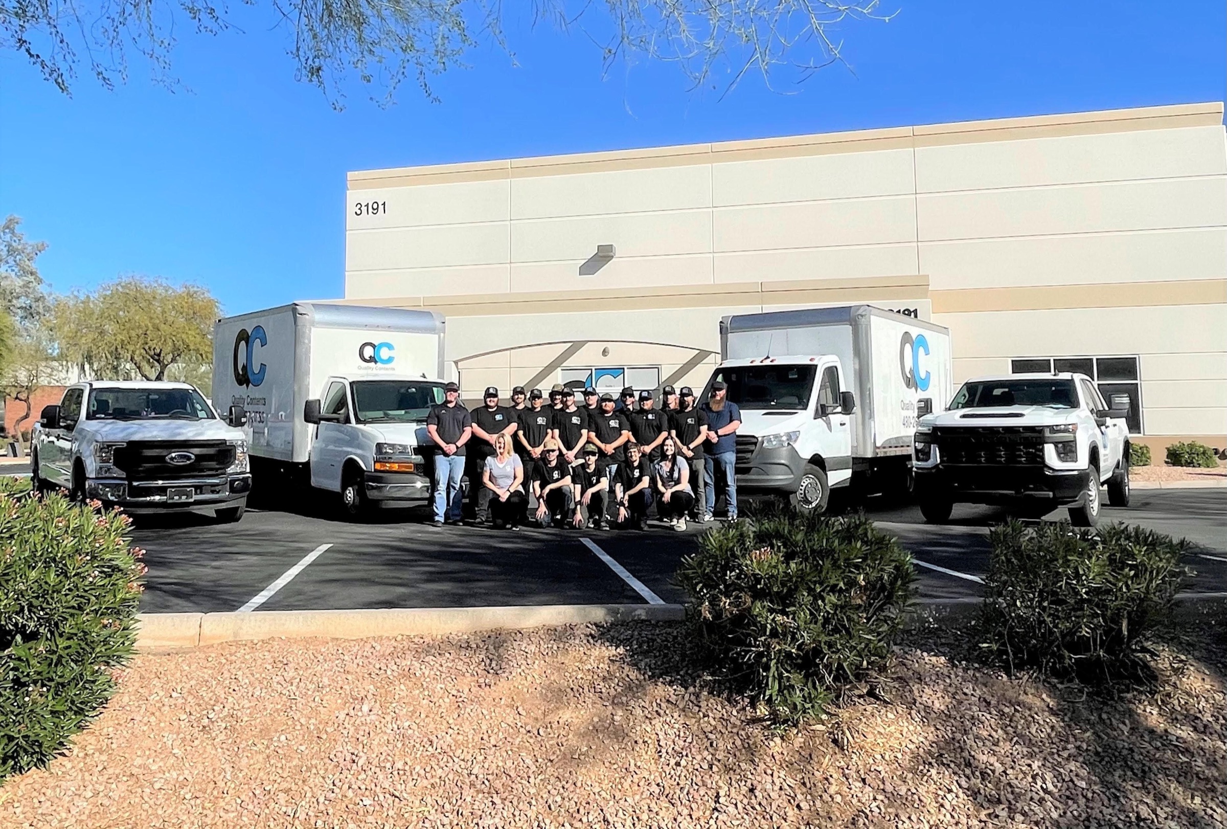 The Quality Contents team with two branded box trucks outside their Chandler, Arizona facility